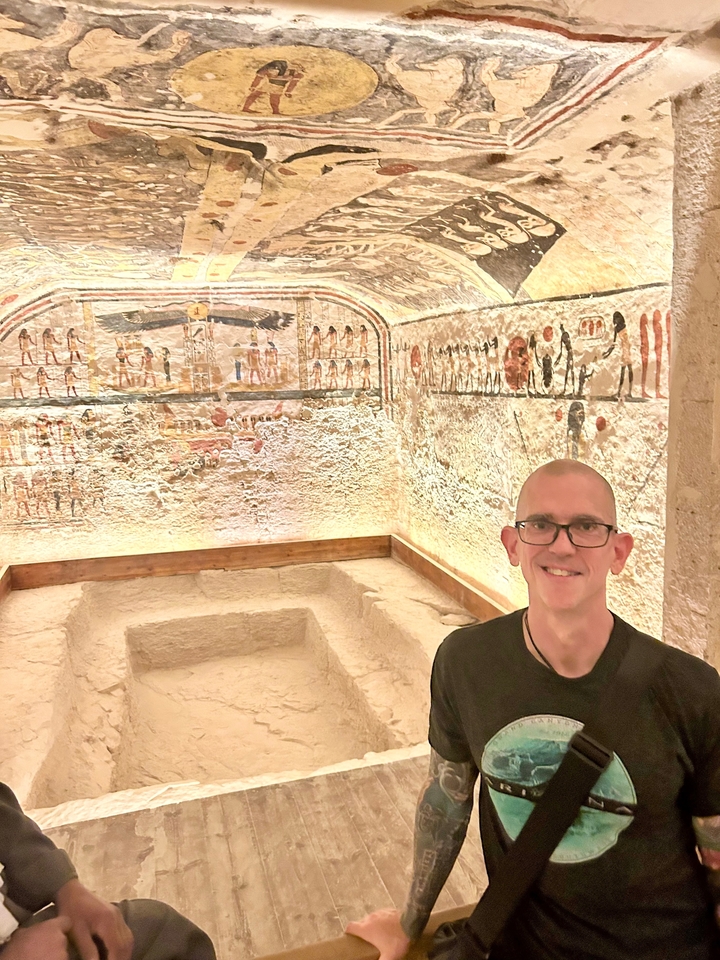 Personne devant un mur couvert de hiéroglyphes illuminés.