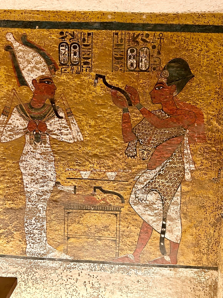 Gros plan de fresques égyptiennes représentant des figures et des rituels.