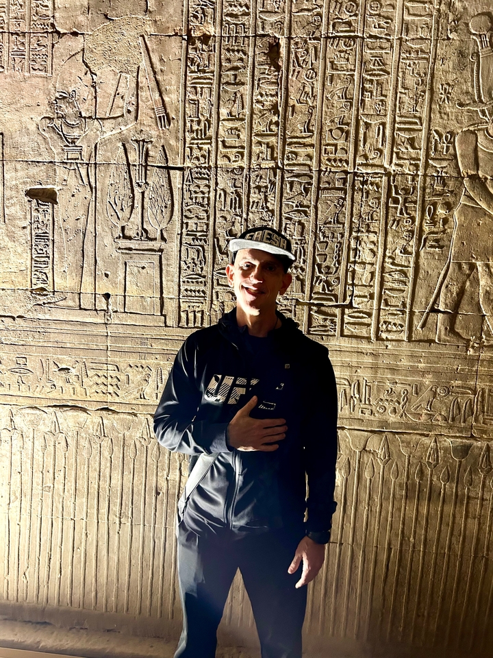 Personne éclairée par un projecteur devant des sculptures.