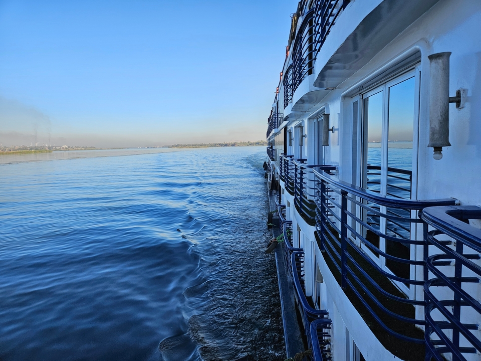 Croisière en bateau à aubes sur une large rivière sous un ciel dégagé.