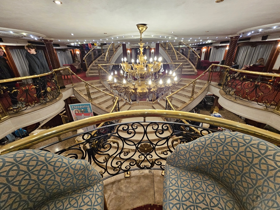Intérieur de navire de croisière de luxe avec lustre et grand escalier.