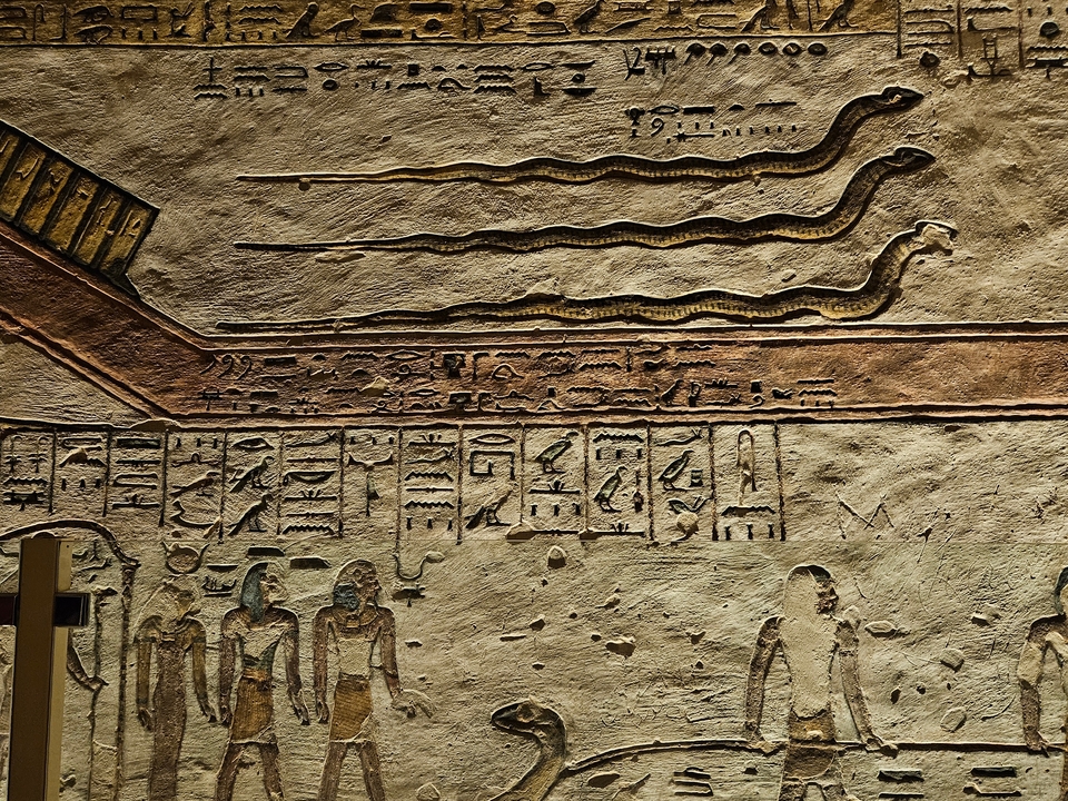 Hiéroglyphes anciens et sculptures sur un mur.