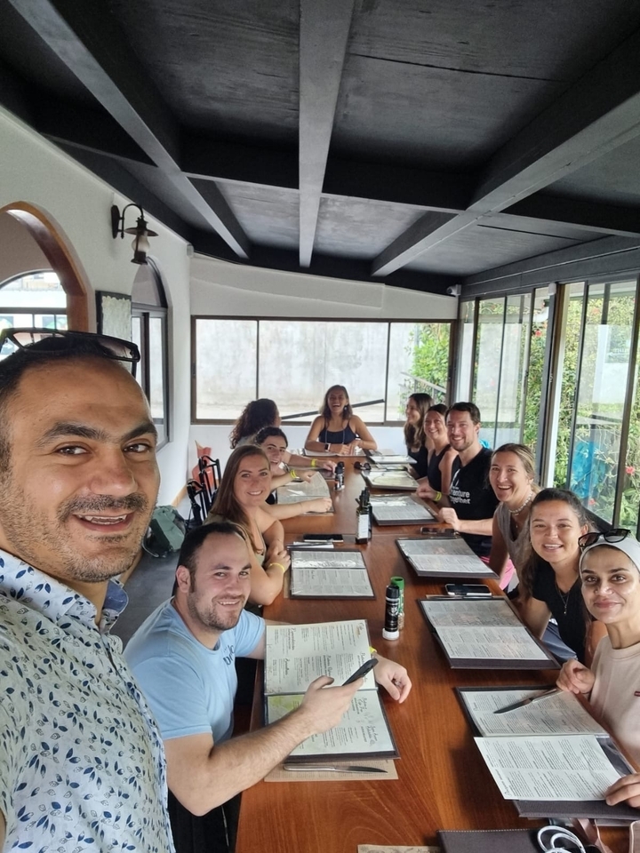 Des gens souriants qui dînent à une table à l'intérieur.