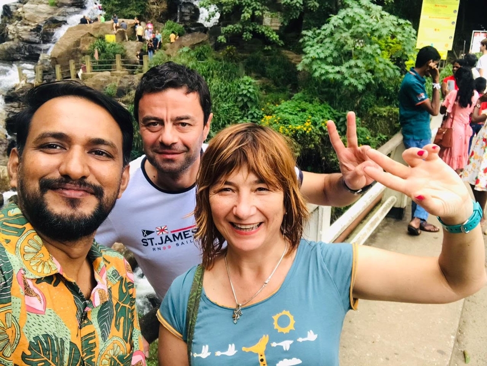 Groupe de personnes prenant un selfie à une cascade.