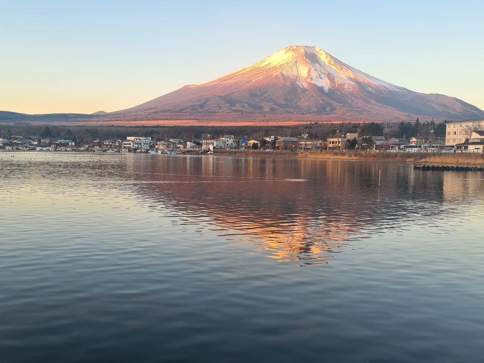 Le mont Fuji avec son reflet sur un lac au coucher du soleil.