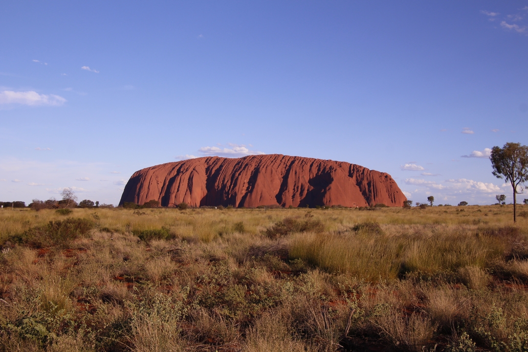 Formación rocosa de Uluru en un paisaje desértico.