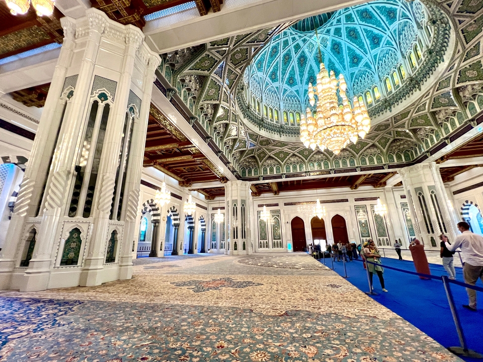 Intérieur orné d'une mosquée avec des lustres et une décoration détaillée.