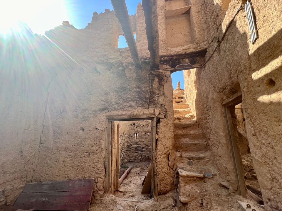 Ruines ensoleillées avec des escaliers de pierre et une architecture ancienne.
