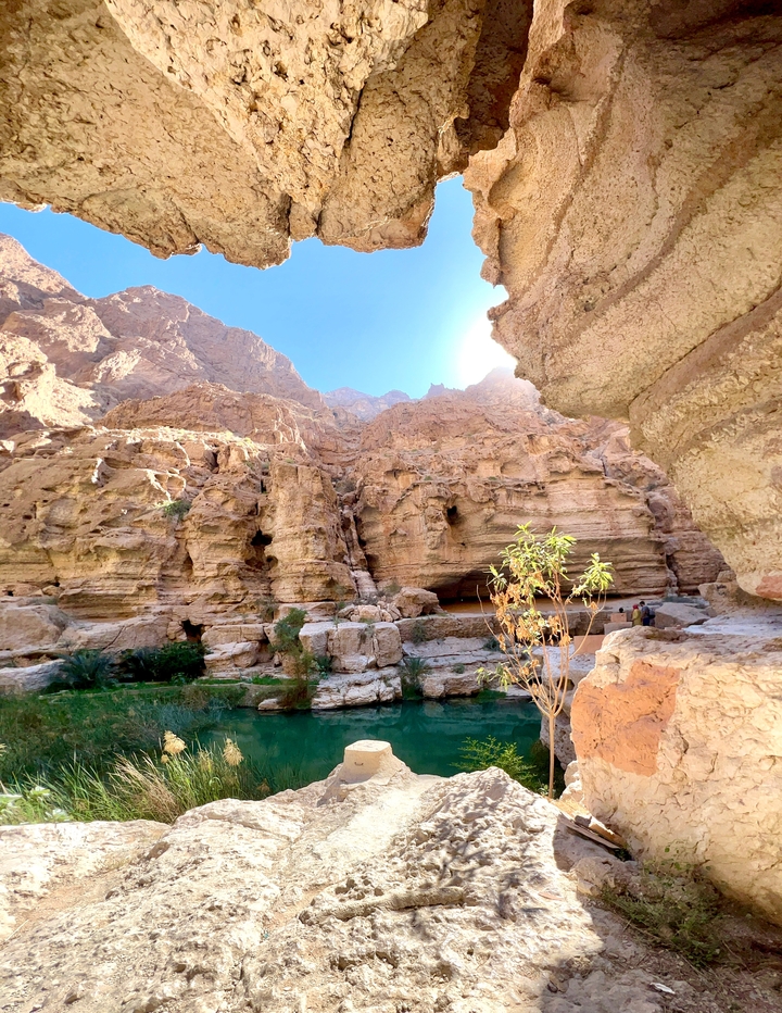 Canyon rocheux avec un petit plan d'eau et du feuillage.