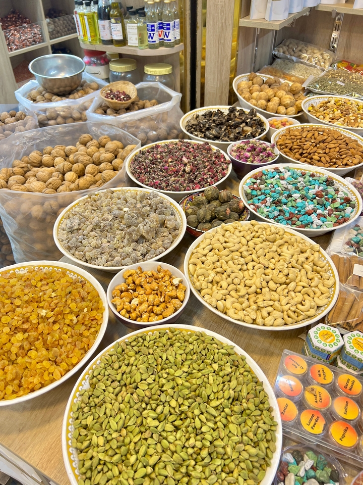 Divers fruits à coque et fruits secs présentés dans des bols sur un marché.