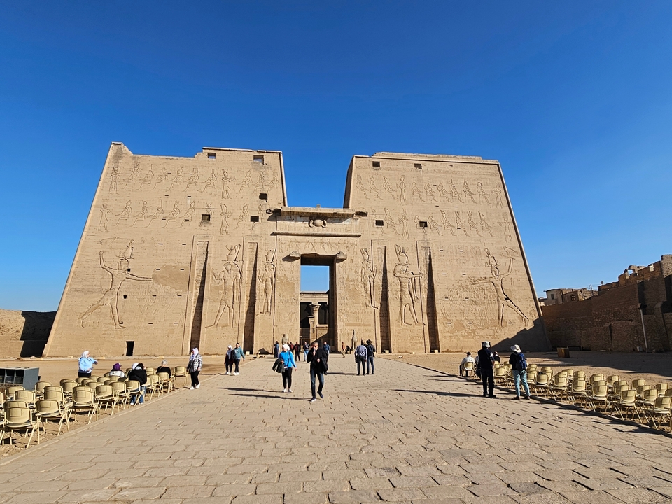 An ancient Egyptian temple with people around.
