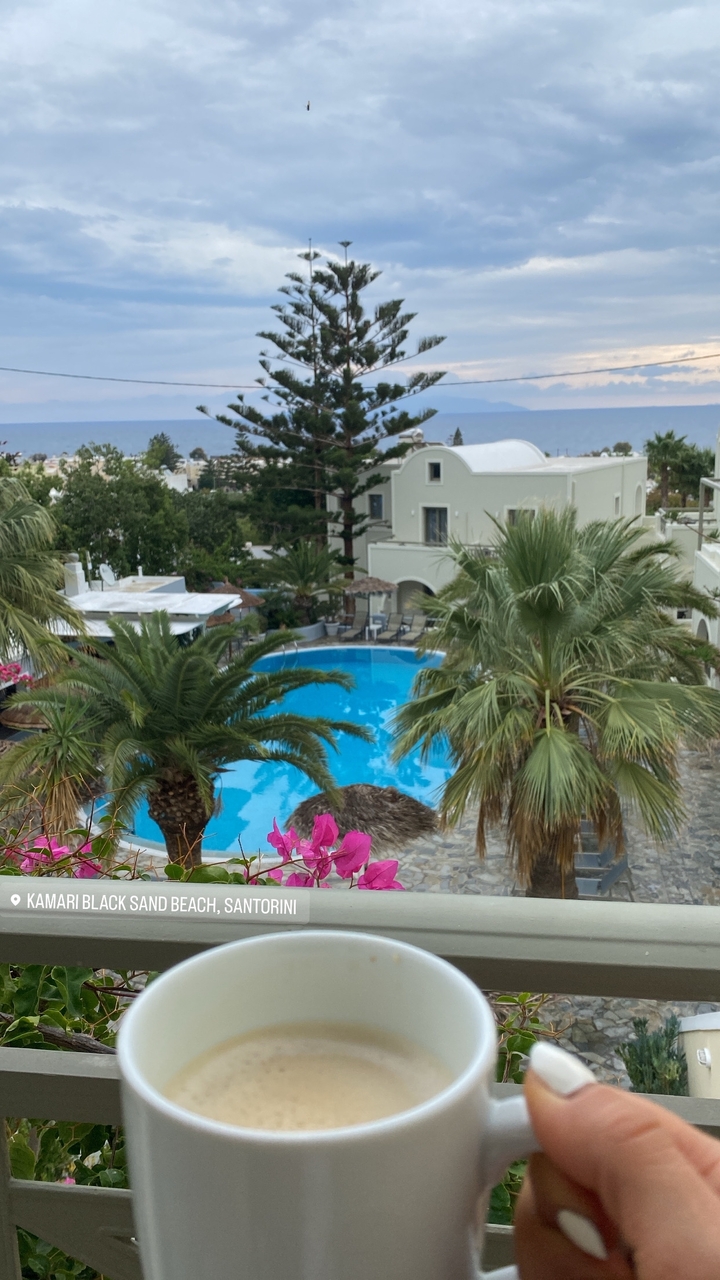 Une piscine d'hôtel entourée de palmiers et de bâtiments.