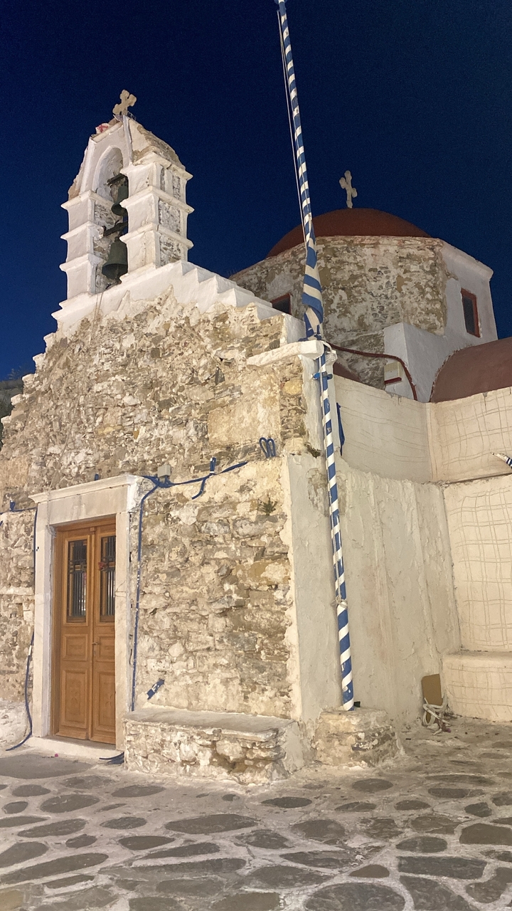 Façade de bâtiment en pierre ancienne et plâtre la nuit.
