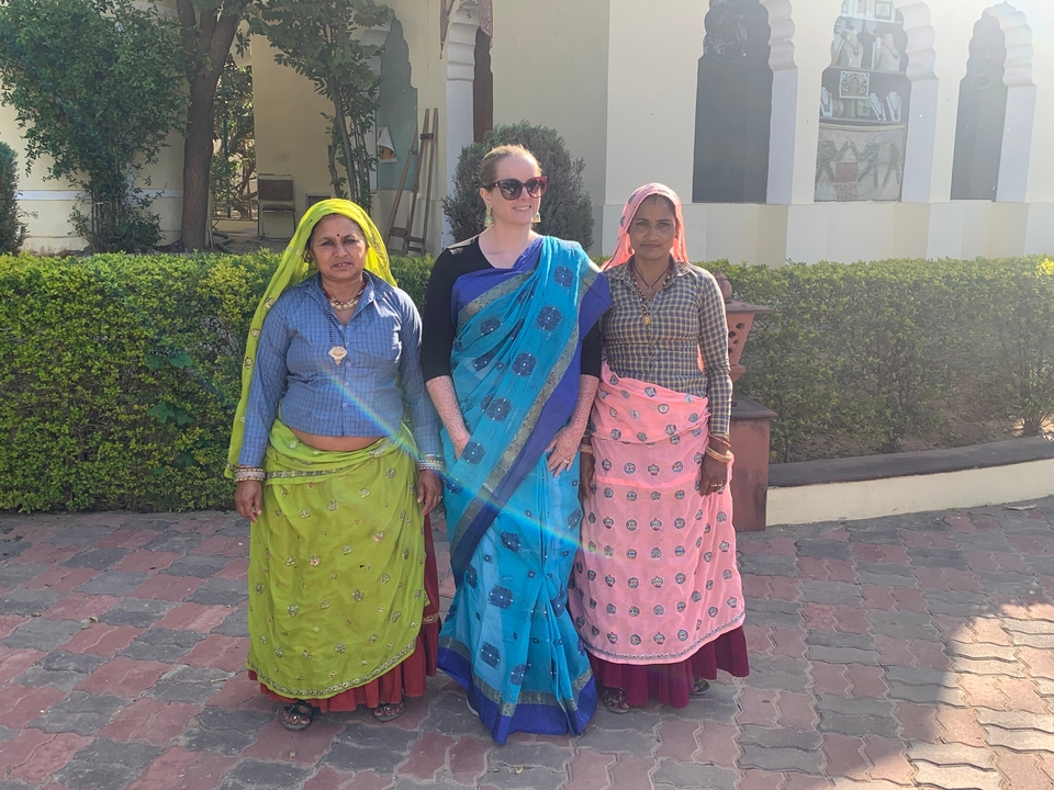 Trois femmes en tenue traditionnelle posant pour une photo.