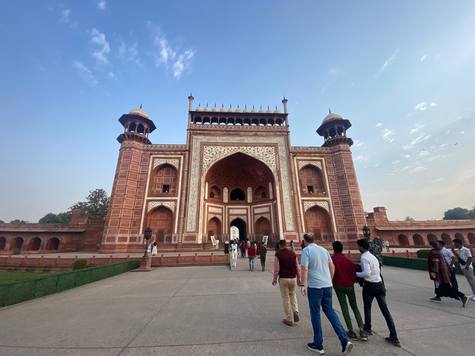 Porte d'une structure historique moghole avec des personnes marchant à l'intérieur.