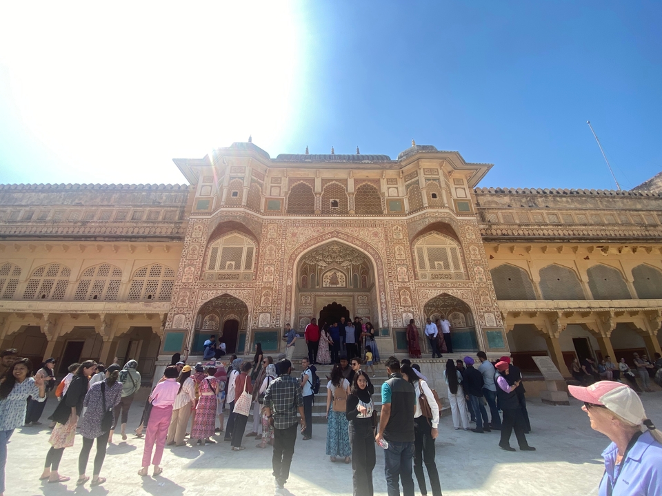Façade ornée d'un palais historique indien avec une foule de visiteurs.