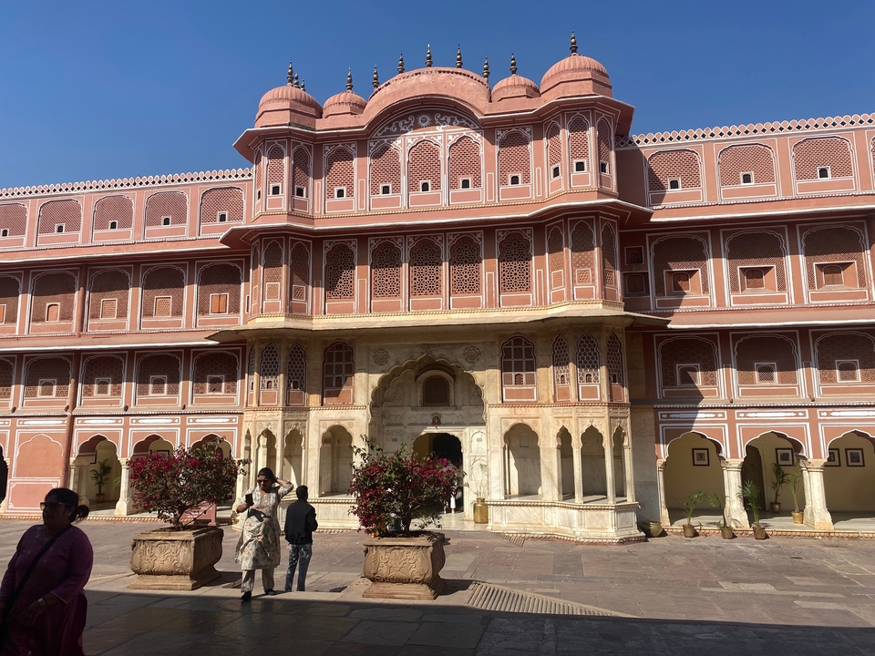 Une façade décorative d'un bâtiment rouge et blanc avec des fenêtres en arc, probablement un monument historique ou culturel.