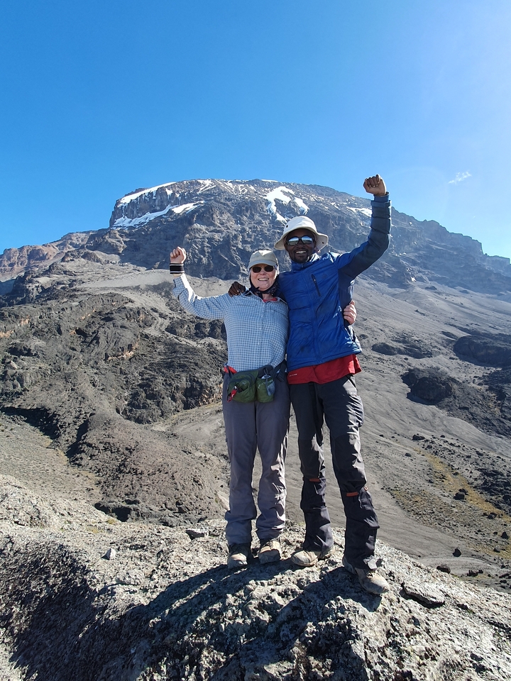 Deux randonneurs posant devant une montagne.