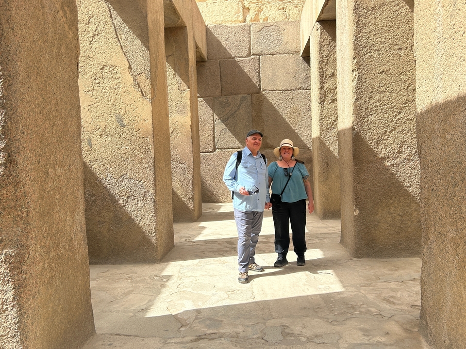 Deux personnes debout dans un temple égyptien antique.