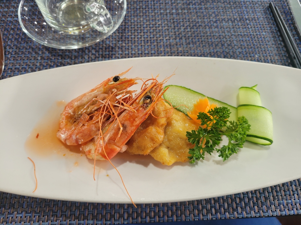 Un plat avec des crevettes et des légumes dans une assiette.