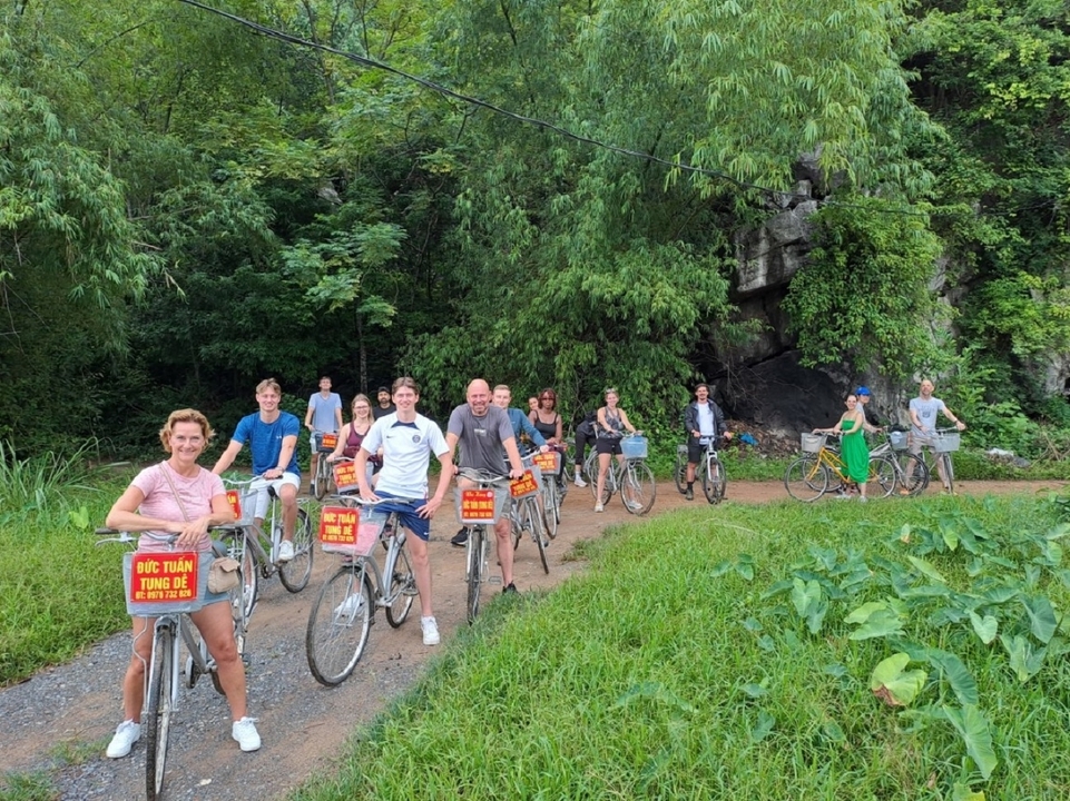 Grand groupe de cyclistes rassemblés sur un sentier dans une végétation luxuriante.