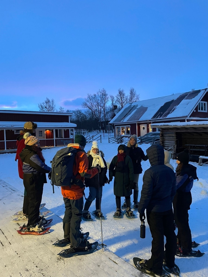 Un groupe de personnes debout dans un village enneigé.