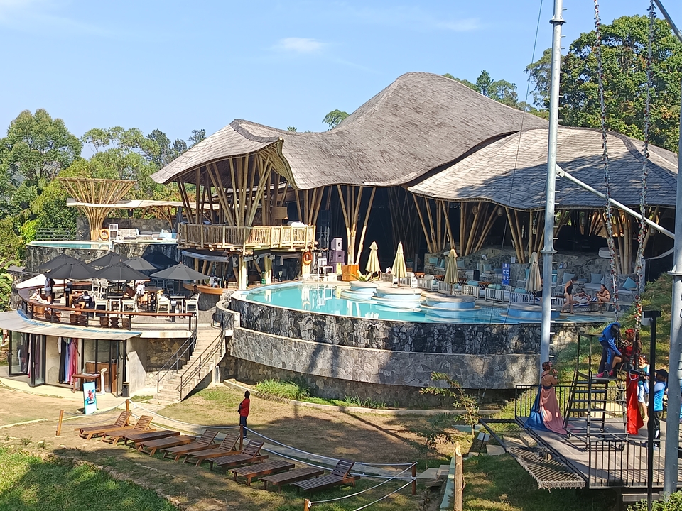Station balnéaire avec piscine et salon extérieur tout autour.