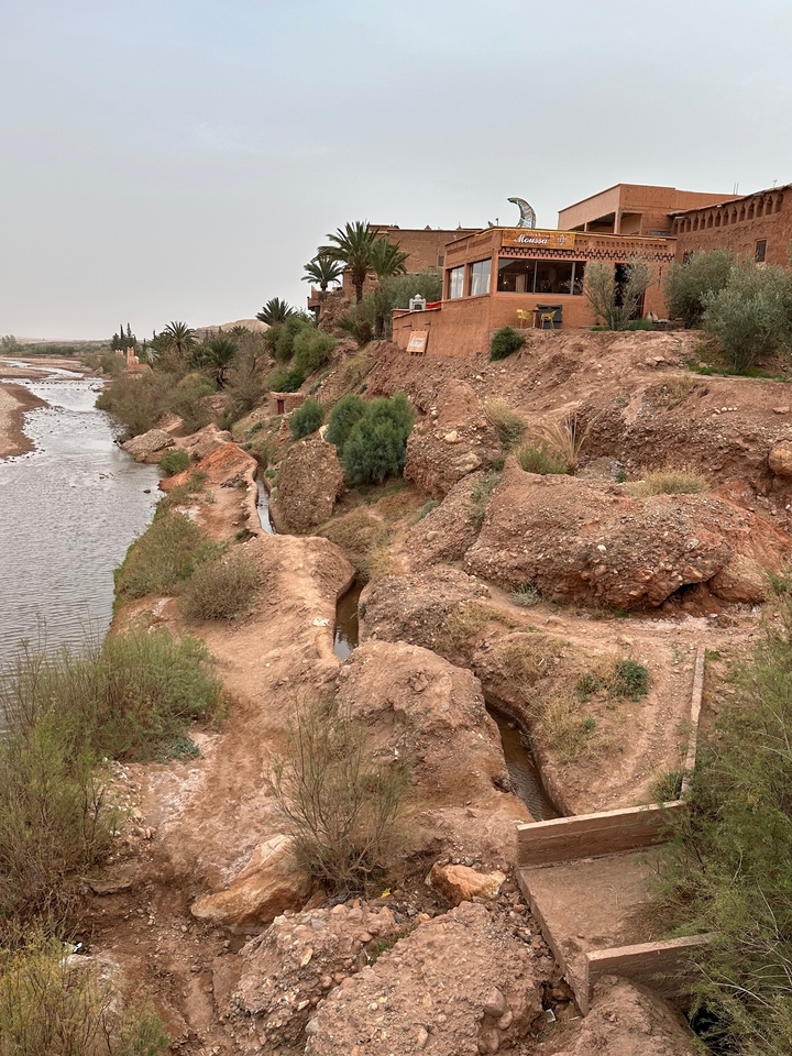 Terrain vallonné et rocheux avec un petit cours d'eau.