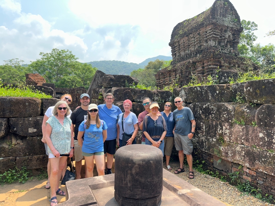 Groupe de touristes devant des ruines antiques.