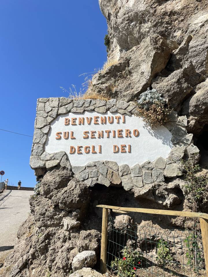A welcome sign in Italian on a stone wall.