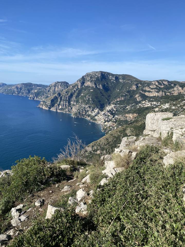 View from a cliff over the sea with a town in the distance.