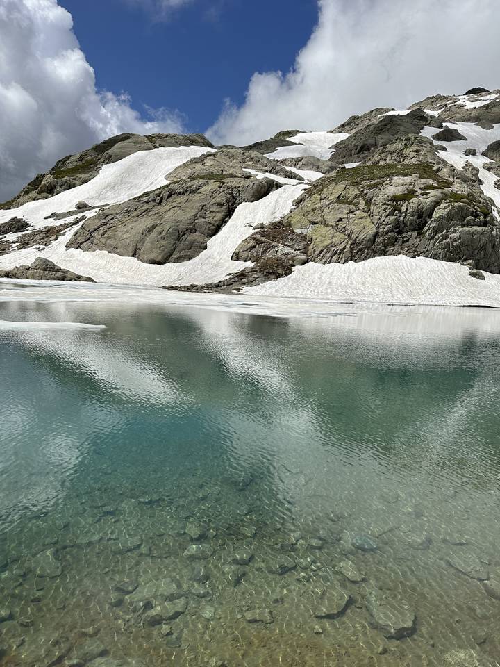 Un lac de montagne serein avec de la neige qui fond.
