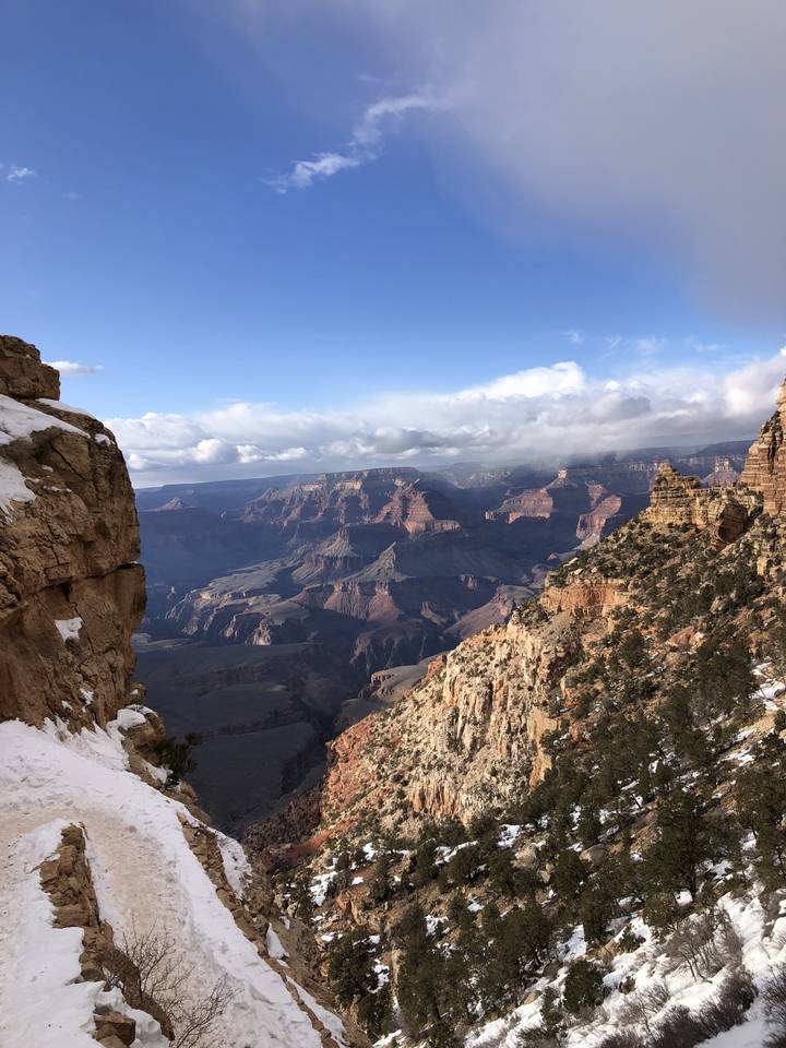 Vue de haut d'un paysage de canyon enneigé et rocheux.
