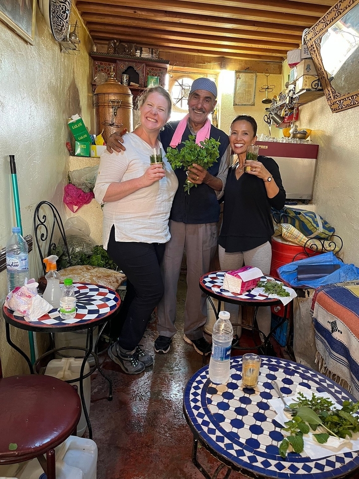 Trois personnes buvant du thé à la menthe dans une petite boutique.