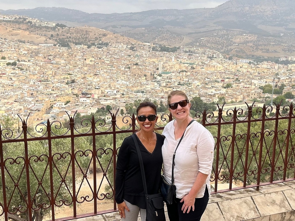Deux femmes posant avec une vue sur une ville.