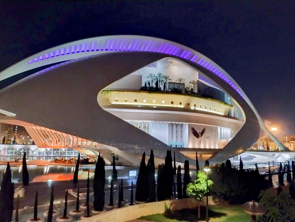 Bâtiment architectural moderne illuminé la nuit.