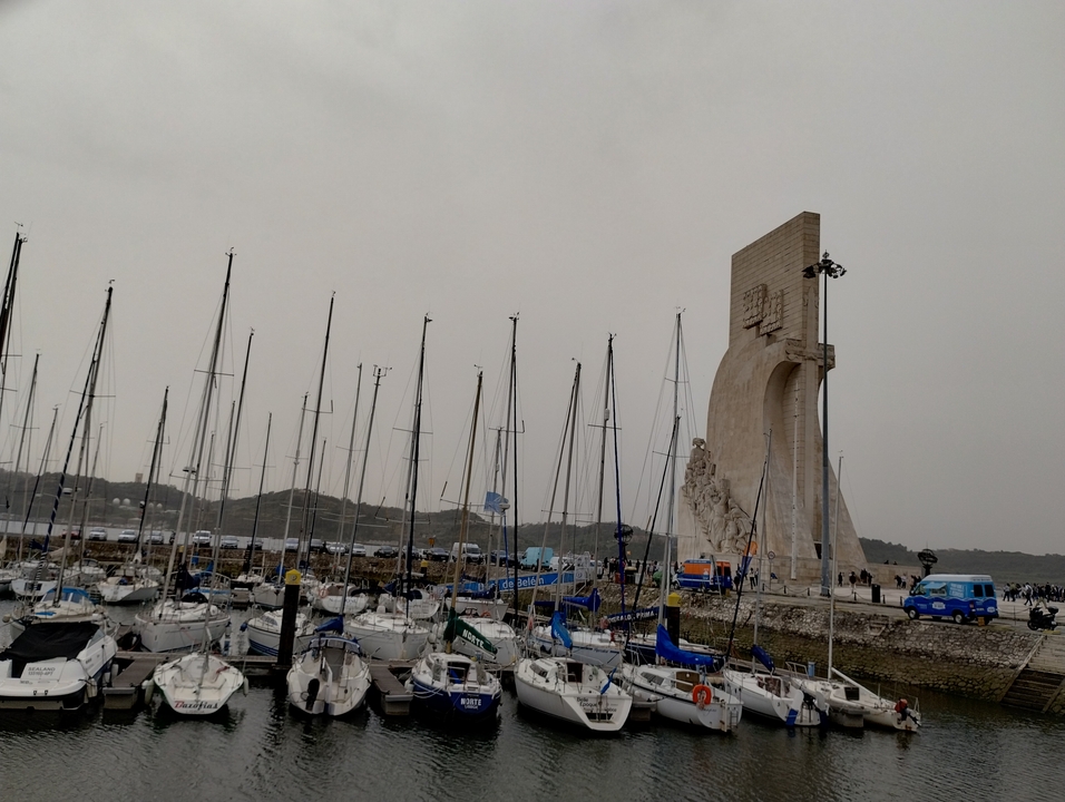 Monument près d'un port de plaisance avec des voiliers.