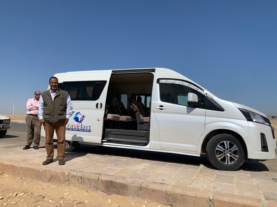 Deux hommes debout à côté d'un fourgon.