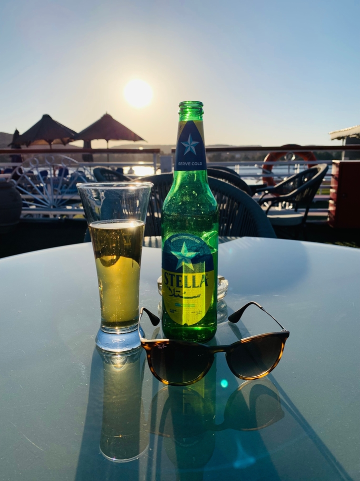 Botella de cerveza sobre una mesa vista al atardecer.