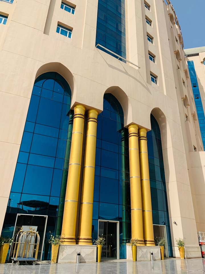 Façade de bâtiment moderne avec des fenêtres bleues et des colonnes jaunes.