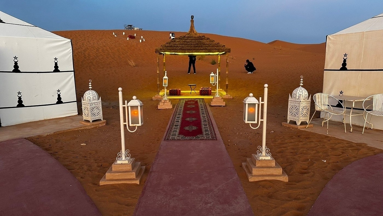 Campement dans le désert avec tentes et lampes à Merzouga.