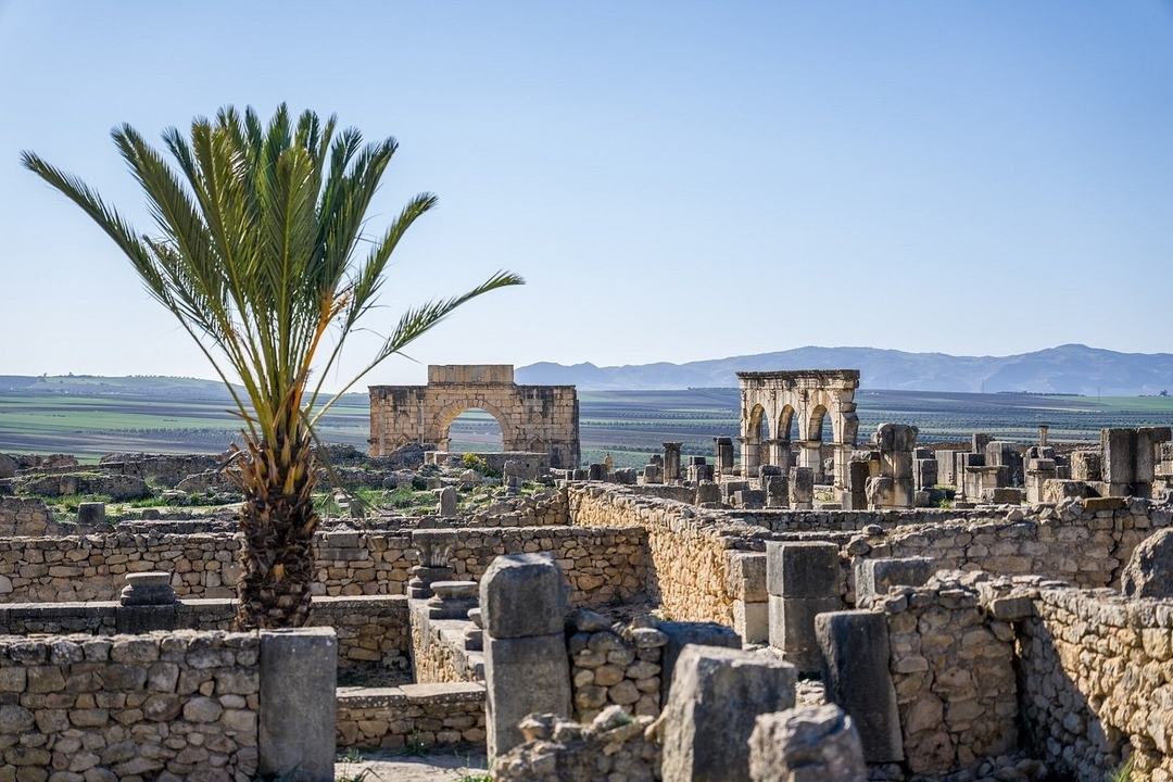Ruines romaines de Volubilis avec les montagnes en arrière-plan.