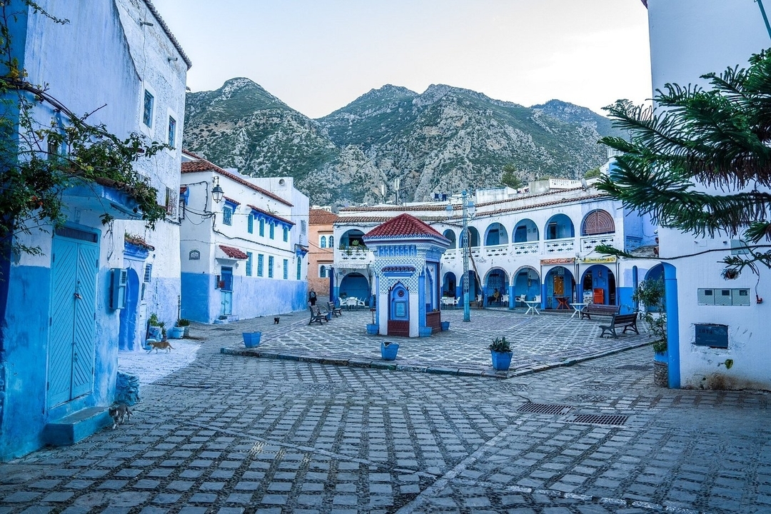 Place pittoresque de la ville de Chefchaouen avec des bâtiments bleus.