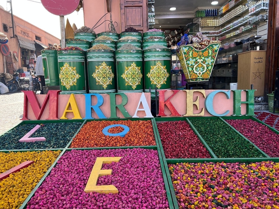 Étalage de marché coloré avec panneau « Marrakech ».