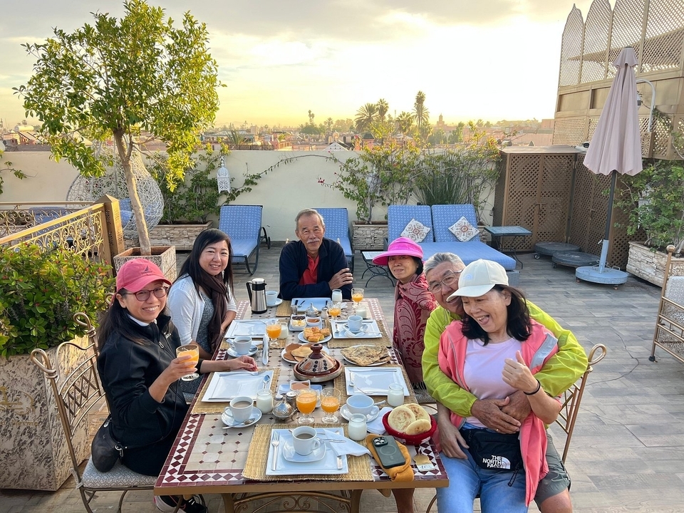 Famille profitant du petit-déjeuner sur une terrasse sur le toit avec vue.