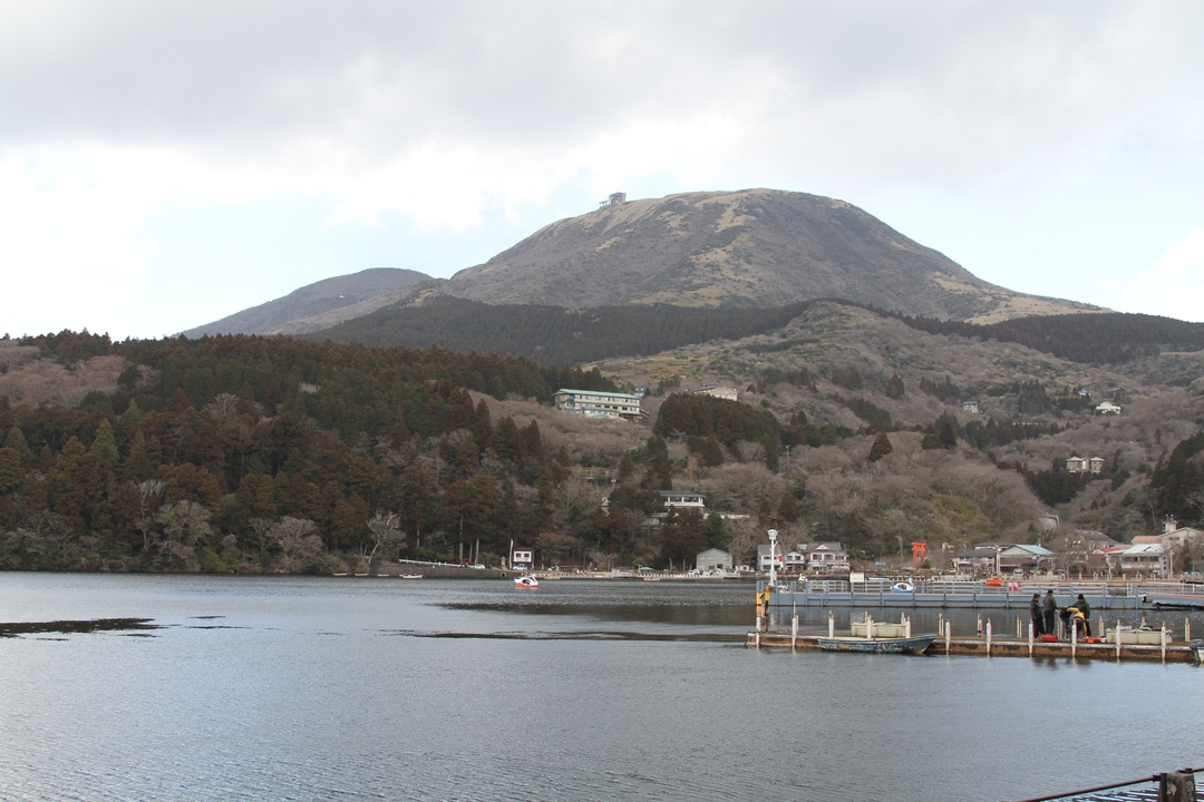 Un lac calme avec une montagne et une forêt en arrière-plan.