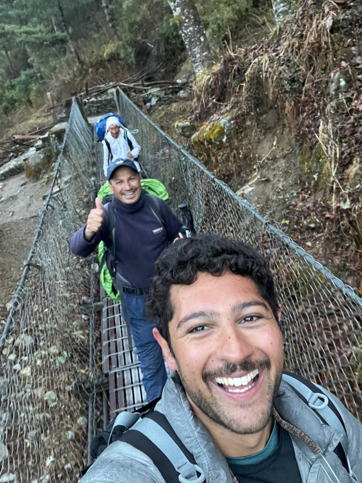 Groupe de personnes faisant de la randonnée sur un pont suspendu