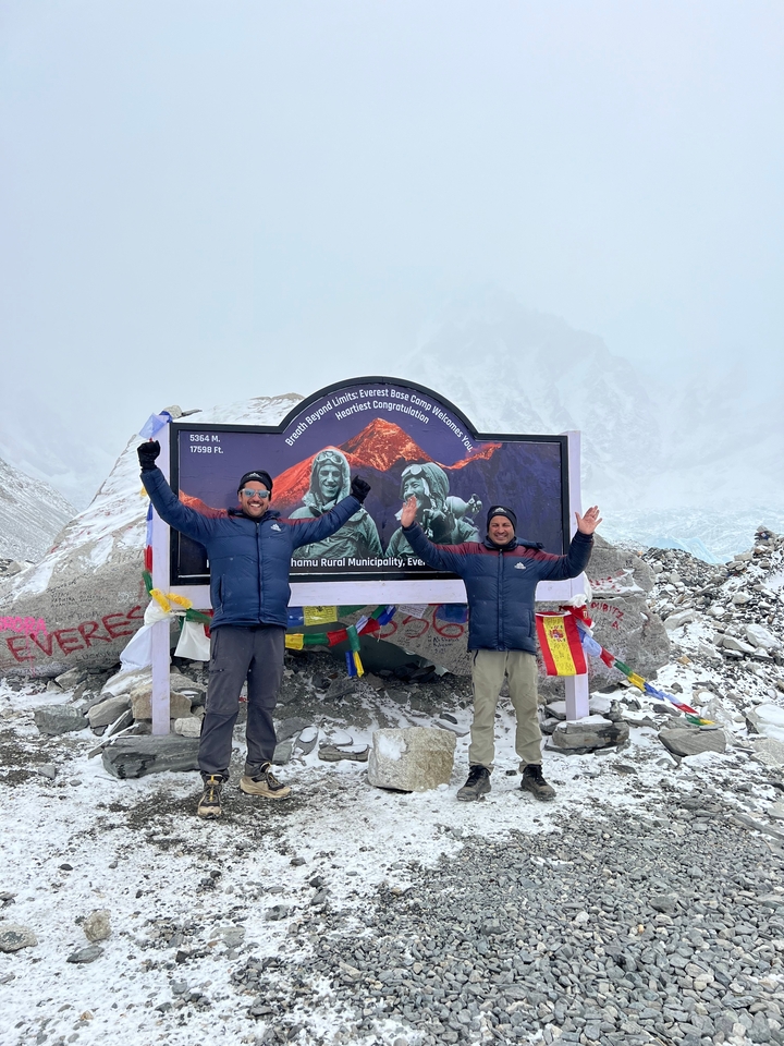 Deux personnes célébrant à un marqueur d'altitude élevée