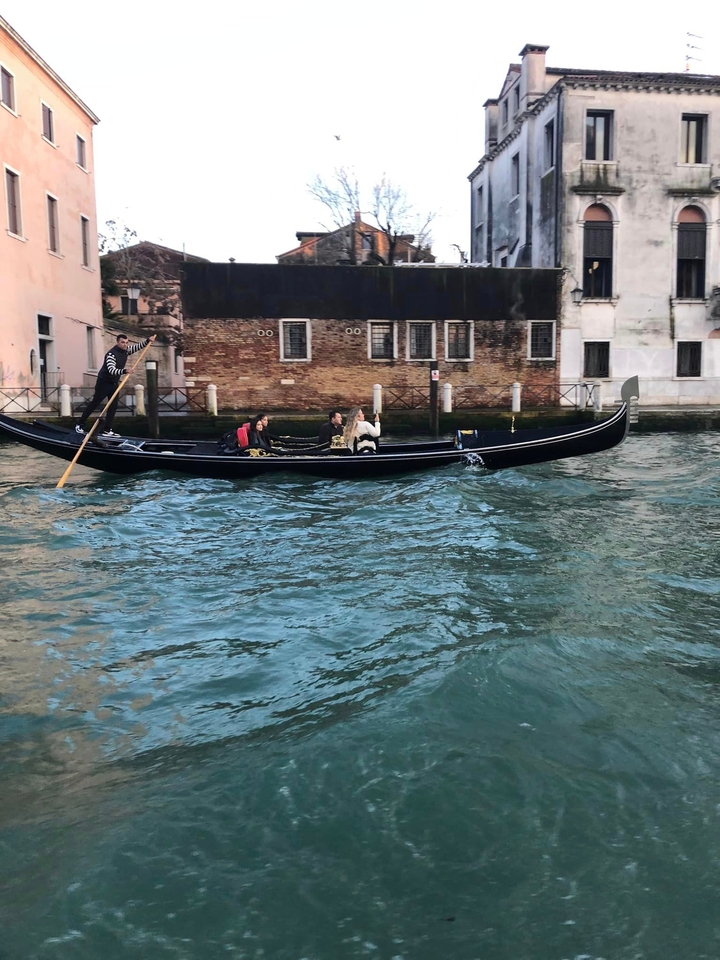 Promenade en gondole avec des touristes dans les canaux de Venise.