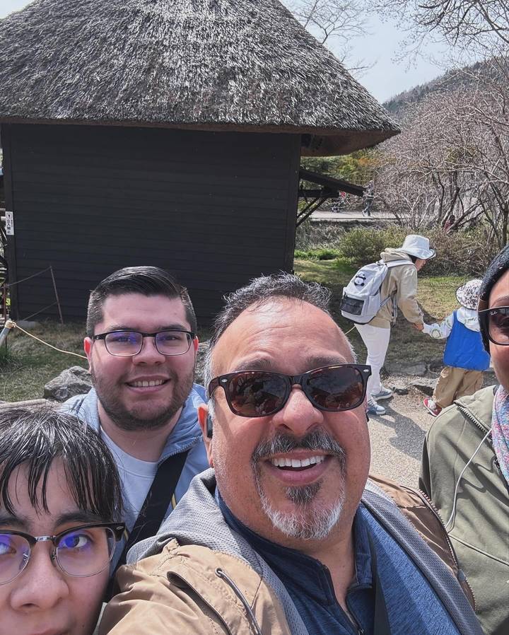Selfie d'un groupe de personnes avec un bâtiment sombre en arrière-plan.